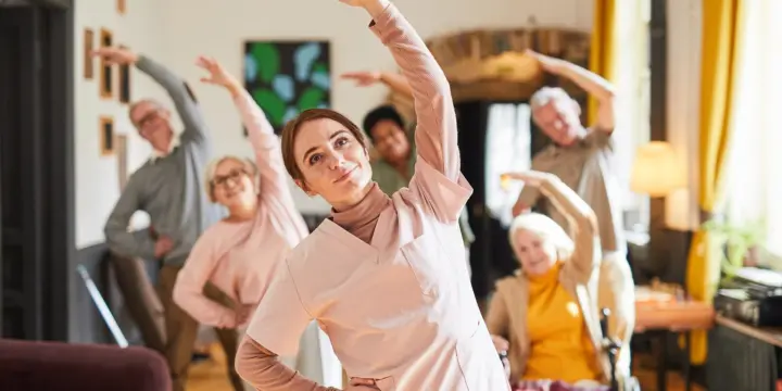 About Us 7 Senior residents in a group exercise class during daily activities in assisted living