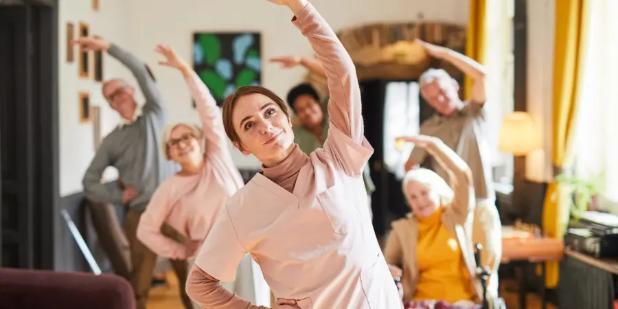 Home 9 Senior residents taking part in a group exercise class during daily activities in residential care